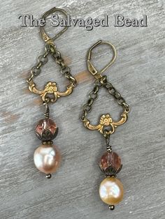 "Inspired by the turn of the 20th century, this gorgeous dangle pair of blush glass and champagne baroque freshwater pearl earrings.  Set in vintage Victorian brass stampings, roll chain, and Czech glass beads. Beautifully elegant and rich in history.  These earrings hang approximately 2 inches. Perfect for any season, to wear into the office, a dressy occasion, or a night on the town!  Own a piece of history, and pass it down as a family heirloom, these earrings are sure to be an eye-catcher! This listing is for 1 pair of earrings. Lavaliere necklace sold separately find it here:  https://thesalvagedbead.etsy.com/listing/1662429924 Each piece is unique & crafted with true artistry. I very much enjoy both the \"picking process\" (the hunt) to research & find the right pieces to marry toget Vintage Pearl Drop Jewelry Gift, Nickel-free Elegant Vintage Jewelry, Vintage Pearl Drop Jewelry For Gift, Elegant Vintage Charm Drop Earrings, Elegant Bronze Wire Wrapped Jewelry, Vintage Wire Wrapped Dangle Jewelry, Vintage Pearl Jewelry With Vintage Charm, Vintage Metal Pearl Earrings For Gift, Vintage Metal Pearl Earrings As Gift