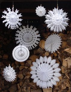 several snowflakes are hanging in a window on the side of a building with logs