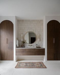 a bathroom with two wooden doors and a rug on the floor