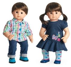 two dolls standing next to each other in front of a book and an adult doll