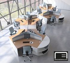 an office cubicle with multiple computer desks and chairs in front of large windows