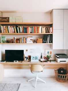 a home office with bookshelves full of books and a computer on the desk