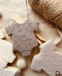 some decorated cookies are sitting on a table with yarn and twine in the background