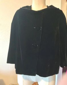 Spectacular vintage 50s black velvet short evening coat. The sleeves are 3/4 length coming a little below the elbow meant to wear with elbow length gloves, high neckline with wide collar for extra detail also for attaching a fur collar, many fur collars were made with pin backs so they could be worn on different coats or sweaters. Length is a little below the waist and is a straight cut not fitted in the waist. The coat is fully lined in black rayon.  There are two oversized velvet covered buttons in front also a large rayon covered snap at the neckline. This is iconic 50s style and so elegant. Made of gorgeous rayon velvet. A perfect little coat to pair with a formal or cocktail dress. Hard to photograph this shinny black velvet it's much prettier in person. It's a warm little coat withou Vintage Velvet Party Outerwear, Vintage Velvet Winter Outerwear, Vintage Velvet Costume Outerwear, Vintage Velvet Outerwear For Costume, Black Velvet Vintage Outerwear, Black Vintage Velvet Outerwear, Vintage Black Velvet Outerwear, 50s Coat, 70s Celebrities