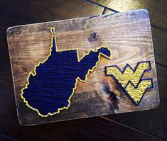 a wooden cutting board with an embroidered minnesota state