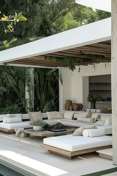 an outdoor living area with white couches and tables