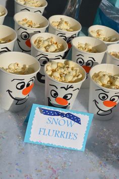 there are many cups with food in them on the table and one has a sign that says snow flurries