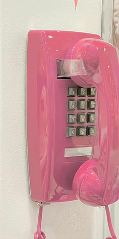 a pink phone is hanging on the wall