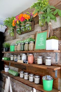 the shelves are filled with jars and flowers on them, along with other items such as plants