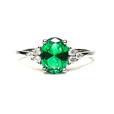 - Handmade - Sterling Silver 925 - Rhodium plated - a type of platinum to prevent the ring from tarnishing - Lab Made Emerald 8mm x 6mm 1.25 Carat - Cubic Zirconias - May Birthstone - 20th Anniversary Gem I made this lovely ring with a gorgeous bright green emerald and sparkling cubics at the sides. This would make a lovely promise or engagement ring. Here is a gorgeous matching band: https://www.etsy.com/listing/1369748569/lab-diamond-moissanite-chevron-band-18k? These are sizable by any decent Emerald Ring With Vvs Clarity For May Birthstone Promise, Classic Cubic Zirconia May Birthstone Ring, Classic Cubic Zirconia Birthstone Ring For May, Classic Green Cubic Zirconia Birthstone Ring, Green Oval Promise Ring, White Gold Emerald Ring With Vs Clarity For May, Sterling Silver Green Diamond Ring With Vs Clarity, Classic Green Crystal Ring With Center Stone, Classic Green Ring With Vs Clarity