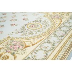 an ornately decorated rug with flowers and scrolls on the bottom, is shown in light blue