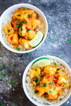 two bowls filled with rice and chicken on top of a table next to lime wedges