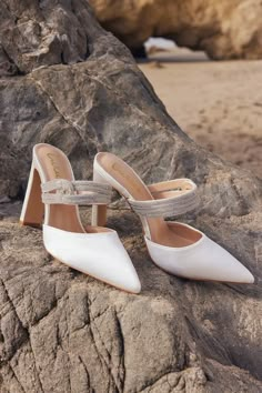 a pair of white shoes sitting on top of a rock