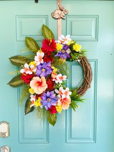 a blue door with a wreath and flowers hanging on it's front door handle