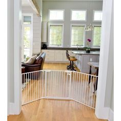 an open door leading to a kitchen and living room in a house with hardwood floors