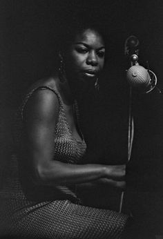 a black and white photo of a woman holding a microphone