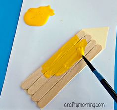 a piece of paper with yellow paint on it next to a pencil and an eraser