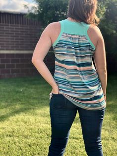 a woman standing in the grass with her hands on her hips