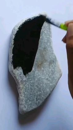 someone is painting a rock with black and white paint