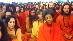 many people are sitting in the middle of a room with orange cloths on them