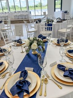 the table is set with blue and gold place settings, silverware, and napkins