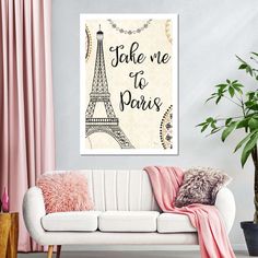 a living room with pink curtains and a white couch in front of the eiffel tower