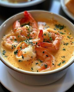 a bowl of soup with shrimp and garnishes