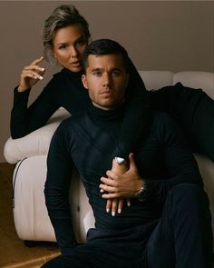 a man sitting next to a woman on top of a couch