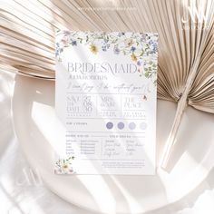 the wedding stationery is laid out on a plate next to an open palm leaf