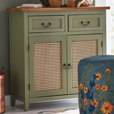 two teddy bears sitting on top of a green cabinet next to a chair and ottoman