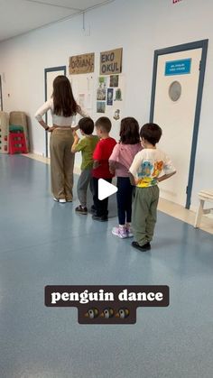 a group of children standing in front of a whiteboard with the words penguin dance on it