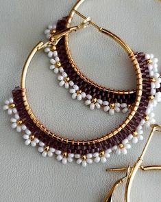 two pairs of hoop earrings with white and brown beads on top of each earring