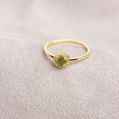 "Peridot: This stone, called the \"Emerald of the Night\" in ancient Egypt, is believed to protect the person using it like a shield. Our round cut ring with peridot stones surrounded by real diamonds is produced to always be with you. It can be given as a gift to yourself, your friends, your lover or your mother. Crown your happy days with our ring. We hope you create beautiful memories with our ring.   Peridot is the birthstone for those born in August. Don't forget to visit our store for all Green Crystal Promise Ring For May Birthstone, Green 14k Gold Promise Birthstone Ring, Halo Diamond Ring For May Birthstone, Halo Design Diamond Ring For May Birthstone, Green Diamond Halo Ring In Round Cut, May Birthstone Halo Ring For Promise, Halo Promise Ring With May Birthstone, Gold Jewelry With Halo Design For May Birthstone, Green Halo Promise Ring