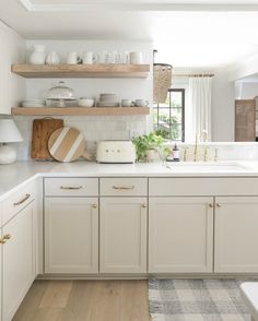 the kitchen is clean and ready for us to use it's white cabinets, counter tops, and shelves