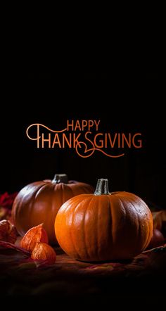 two pumpkins sitting on top of a table next to each other with the words happy thanksgiving