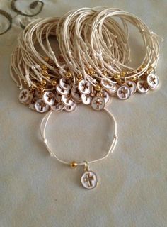 several bracelets are sitting on top of a white tablecloth with gold and silver beads