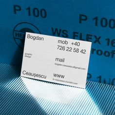 a business card sitting on top of a blue piece of paper