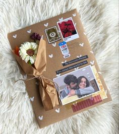 a brown envelope with some pictures and flowers on the inside is tied to a white furnishing