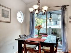 a dining room table with chairs and a vase on it