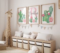 a room with three pictures hanging on the wall and two stuffed giraffes