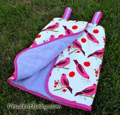 an oven mitt laying on the grass next to a pot holder with a towel