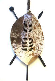 a brown and white cow hide with two black sticks sticking out of it's side