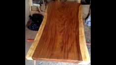 a wooden table top sitting on top of a hard wood floor next to a chair