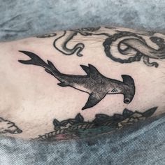 a man with a tattoo on his arm has a shark and sea creatures around him