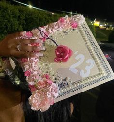 a woman holding up a decorated sheet with flowers and pearls on it's head