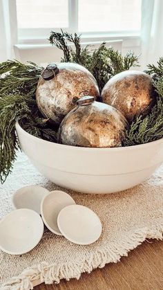 a white bowl filled with ornaments on top of a table