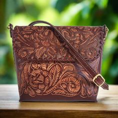 Unleash Your Wild Side with our Hand-Tooled Leather Bags! 🌿✨ Perfect for the free-spirited fashionista who loves unique, one-of-a-kind pieces. Each bag is meticulously crafted by skilled artisans, making it a true work of art. Stand out from the crowd and add a touch of bohemian flair to your outfit with our hand-tooled leather bags.  🌹height: 19 cm. 7 1/2 inch 🌹width : 22 cm.  9 inch 🌹base:10 cm.    4  inch Large  adjustable and detachable strap:119 cm  47 inches interior: suede leather mag Brown Embossed Shoulder Bag For Everyday, Brown Embossed Tote Shoulder Bag, Brown Embossed Crossbody Shoulder Bag, Artisan Brown Embossed Shoulder Bag, Brown Hand Tooled Clutch Bag, Brown Engraved Bags For Everyday Use, Brown Engraved Leather Shoulder Bag, Brown Leather Engraved Shoulder Bag, Engraved Brown Bags For Everyday Use