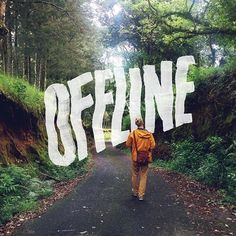 a person walking down a road with the words offline painted on it