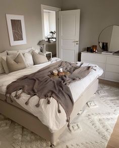 a bedroom with a large bed covered in blankets and pillows on top of it's headboard