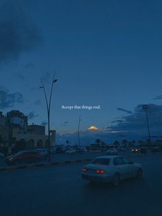 a car that is sitting in the street at night with an overcast sky behind it